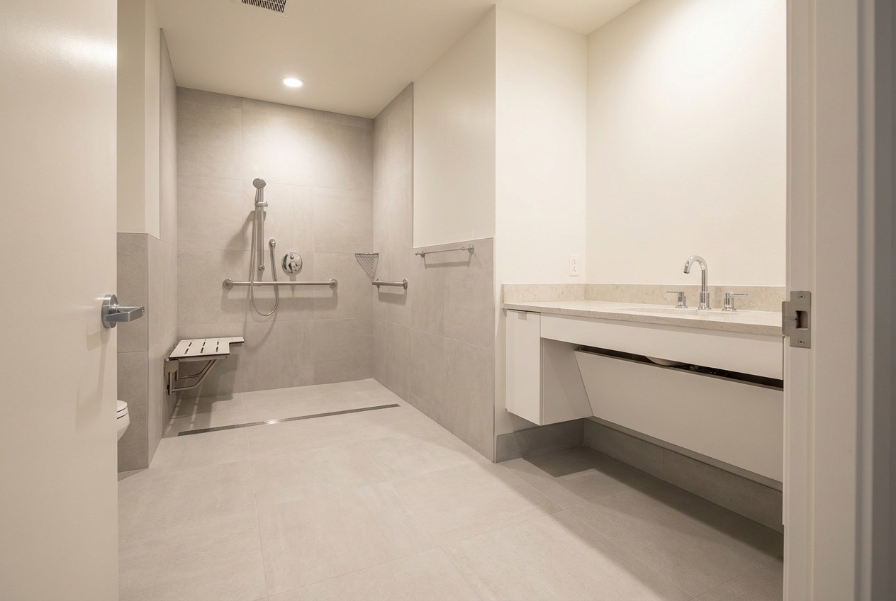 Wheelchair accessible bathroom with wide doorway, wall-mounted vanity, and full turning radius